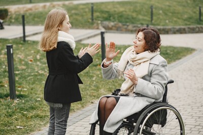 Parent in wheelchair in handclap game with child
